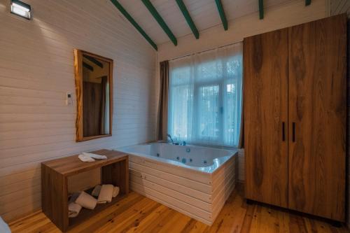 萨卡里亚SAPANCA BAMBOOLOW RESORT的带浴缸和窗户的浴室