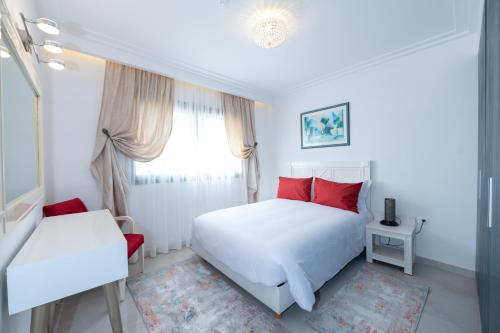 阿加迪尔Villa Palmeraie Golf Agadir的白色卧室配有红色枕头和床