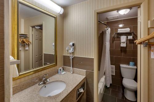 米西索加Quality Inn Toronto Airport的一间带水槽、卫生间和镜子的浴室
