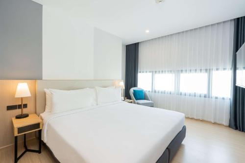 曼谷Best Western Nada Don Mueang Airport hotel的卧室设有一张白色大床和一扇窗户。