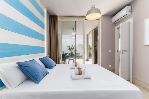 佩斯科勒海滨Mare Villas Pescoluse- Design Apartment的卧室配有带蓝色枕头的大型白色床
