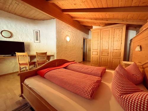 齐勒河谷采尔Schulhaus Tirol的一间卧室配有红色和白色枕头的床
