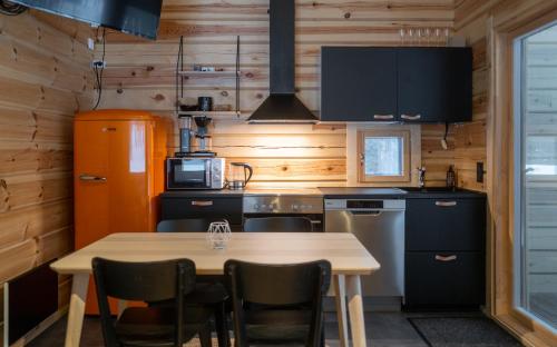 基蒂莱Black Work Levi Aihki的厨房设有木墙和桌椅