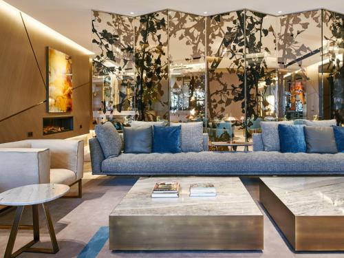 马德里VP Plaza España Design的客厅配有蓝色的沙发和桌子