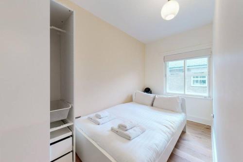 伦敦Lovely 2-bedroom flat with parking near Highgate的一间小卧室,配有白色的床和窗户