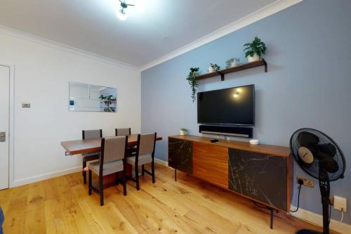 伦敦Lovely 2-bedroom flat with parking near Highgate的客厅配有餐桌和平面电视。