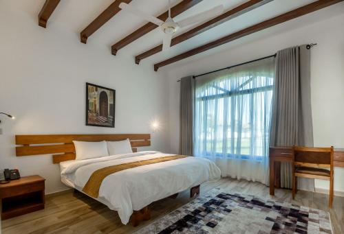 达累斯萨拉姆Aya Sophia Villa Garden Hotel的一间卧室设有一张床和一个大窗户