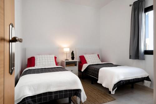 宏达海滩Apartamento La Estrella I的带窗户的客房内设有两张单人床。