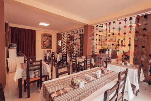 库斯科Hotel Las Quenas的一间在房间内配有桌椅的餐厅