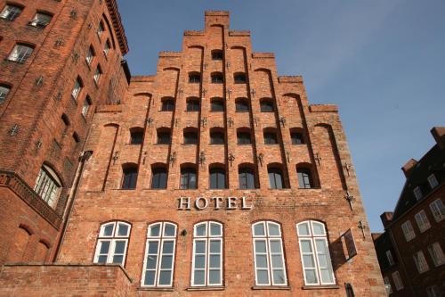 吕贝克安诺1216酒店的一座大型砖砌建筑,上面写着酒店字