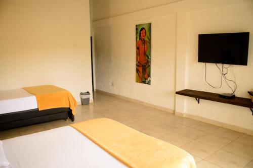金巴亚Finca Hotel Loma Verde的客房设有两张床和一台平面电视。