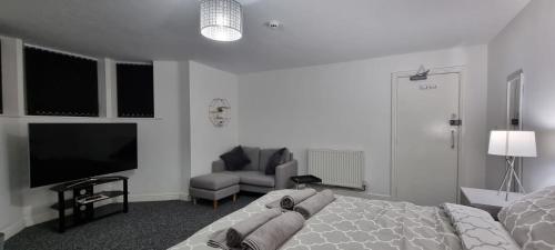 哈利法克斯Ultra-Fine APARTMENTS in CENTRAL HALIFAX的一间卧室配有一张床、一台电视和一把椅子