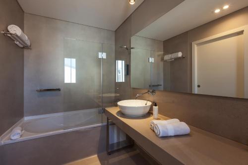 维塞乌Avenida Boutique Hotel的浴室配有盥洗盆和浴缸。