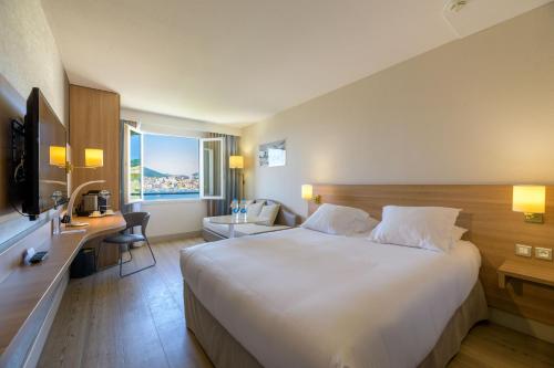 阿雅克修阿雅克肖阿米雷特贝斯特韦斯特酒店的酒店客房设有一张大床和一张书桌。