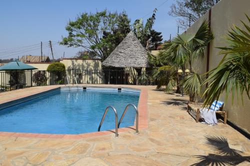 阿鲁沙Stasumo House Arusha的一座大游泳池,位于一座带建筑物的庭院内