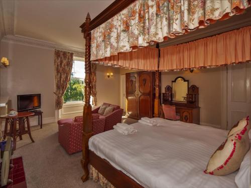 达尔比蒂克罗亚德别墅酒店的一间带天蓬床的卧室和一间客厅