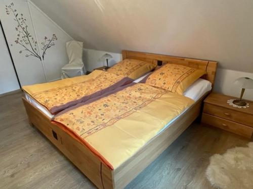 施马伦贝格Ferienwohnung Wilzenbergblick的一间卧室配有一张大床和木制床头板