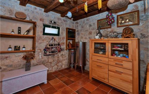 SlivnoGorgeous Home In Slivno With Heated Swimming Pool的一间带木制橱柜和电视的浴室