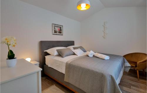 SlivnoGorgeous Home In Slivno With Heated Swimming Pool的一间卧室配有一张带椅子和桌子的床