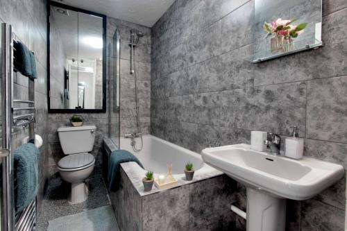 埃奇韦尔Welshside - Modern One Bedroom House, Welsh Harp, NW London By MDPS的浴室配有盥洗盆、卫生间和浴缸。