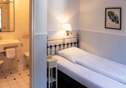 拉芬斯堡奥伯托酒店的一间卧室配有床、水槽和卫生间