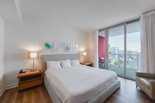 哈兰代尔海滩Cozy 1BR Condo Beachwalk Resort的卧室设有白色的床和大窗户