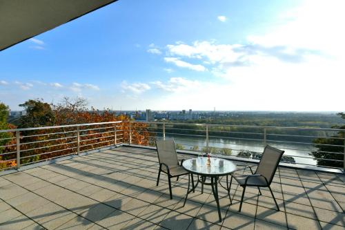 布拉迪斯拉发River View Apartments Hotel的阳台的天井配有桌椅