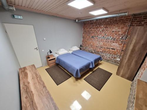 纳尔瓦Narva Port Hostel的一间设有蓝色床的砖墙卧室