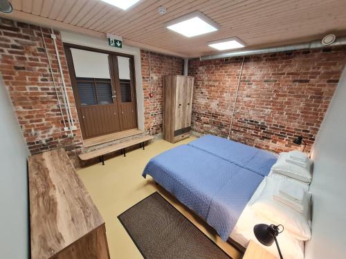 纳尔瓦Narva Port Hostel的卧室配有砖墙内的床铺