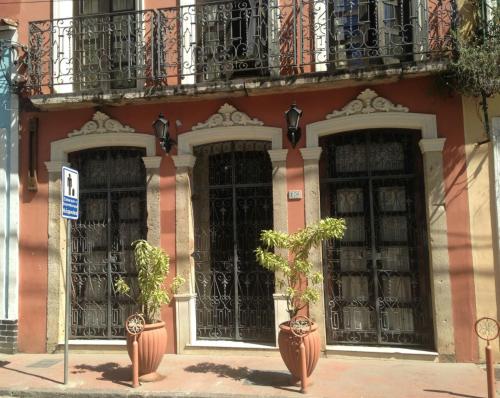 萨尔瓦多索尔卡尔穆套房公寓的前面有黑色大门和盆栽植物的建筑