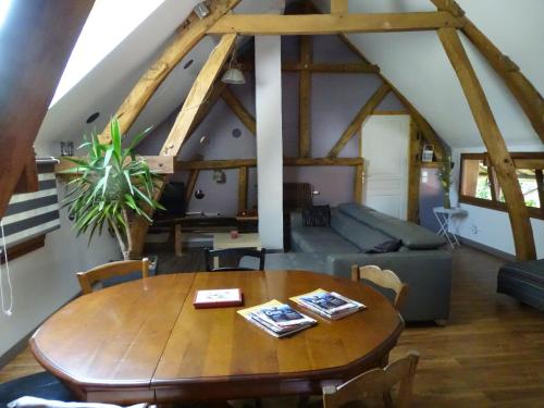 RentyLe gîte de l'AA的客厅配有木桌和沙发