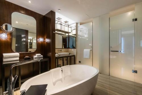 无锡无锡太湖华邑酒店的一间带大浴缸和镜子的浴室