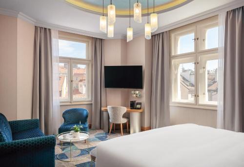 布拉格Allure Hotel Prague的酒店客房带一张床、一张桌子和椅子