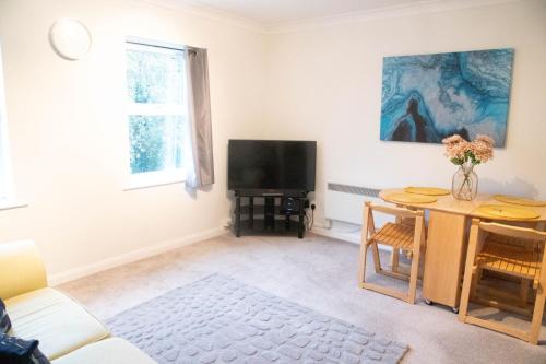 BuckinghamshireLovely 1 bedroom Apartment High Wycombe的客厅配有桌子和电视