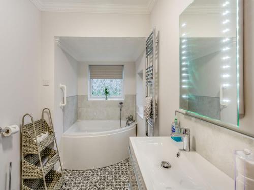 HeighingtonFeatherstone House的白色的浴室设有浴缸和水槽。