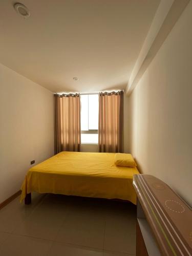 特鲁希略Hermosa departamento vanguardista c/ balcon .的一间卧室设有黄色的床和窗户。