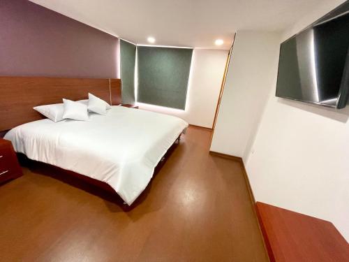 帕斯托HOTEL HOME的一间卧室配有带白色床单和枕头的床。