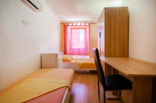 科佩尔Hostel Martin的客房设有两张床、一张桌子和一个窗户。