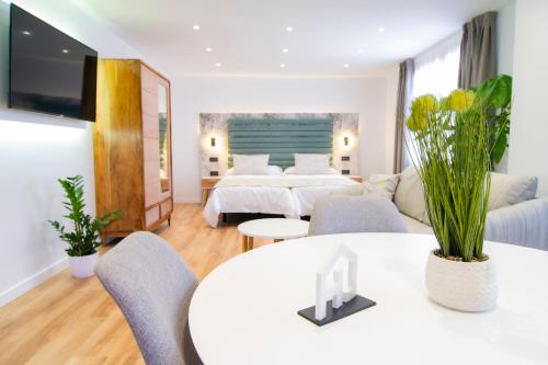 拉拉古纳Laguna Home & Suites的酒店客房带两张床和一张桌子以及椅子。