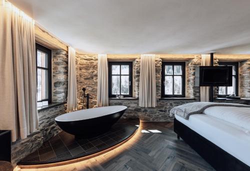 萨姆瑙恩LARET private Boutique Hotel - Adults only的一间带浴缸、床和电视的卧室