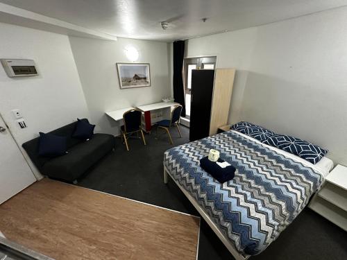 奥克兰哥伦比亚公寓酒店的客房设有床、沙发和桌子。