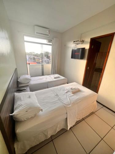 IbiapinaHotel Pinheiro的酒店客房设有三张床和窗户。