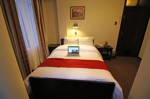 普诺Camino Real Puno的酒店客房,配有一张带笔记本电脑的床