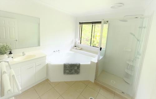 黄金海岸Gold Coast uninterrupted uphill view & big pool的白色的浴室设有水槽和淋浴。