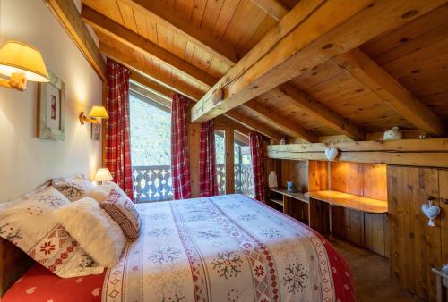 谷雪维尔Magnifique chalet authentique au cœur des 3 vallées的一间带一张床的卧室,位于带木制天花板的房间内
