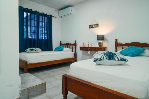 圣卡塔利娜岛Sunset Catalina的一间卧室配有两张带蓝色枕头的床