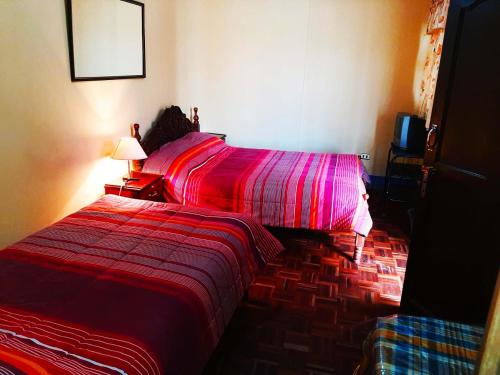 波托西Hostal Compañía de Jesús的一间卧室配有一张红色棉被的床