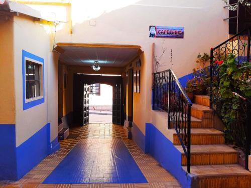 波托西Hostal Compañía de Jesús的走廊上设有蓝色和橙色的墙壁和楼梯