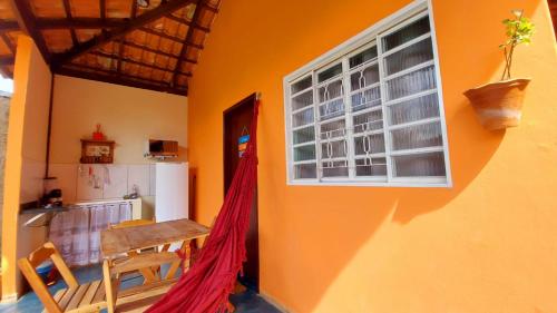 戈亚斯州上帕莱索Chalés Flor de Manacá的客房设有桌子、厨房和窗户。