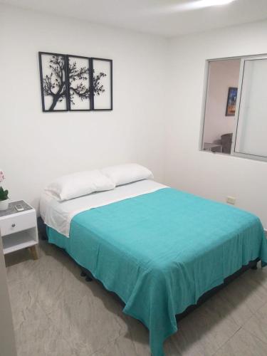 比亚维森西奥APARTA ESTUDIO CONDO的白色卧室配有一张带蓝色毯子的床